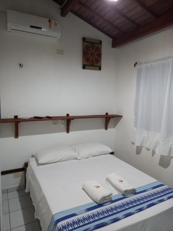 傑里科科拉的住宿－Pousada do farol，一间卧室配有一张床,上面有两条毛巾