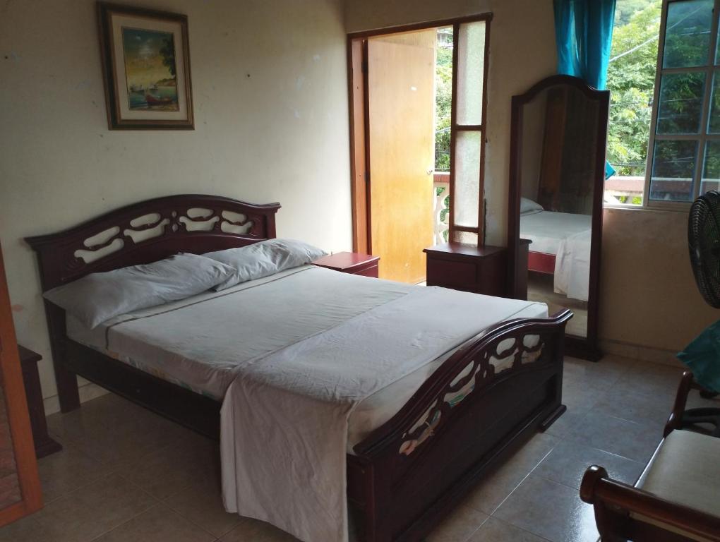 1 dormitorio con 1 cama grande en una habitación en Cabaña dulce sueños, en Taganga