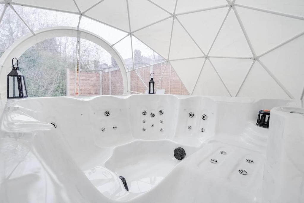 - une baignoire blanche dans une chambre avec fenêtre dans l'établissement Alford house, à Manchester