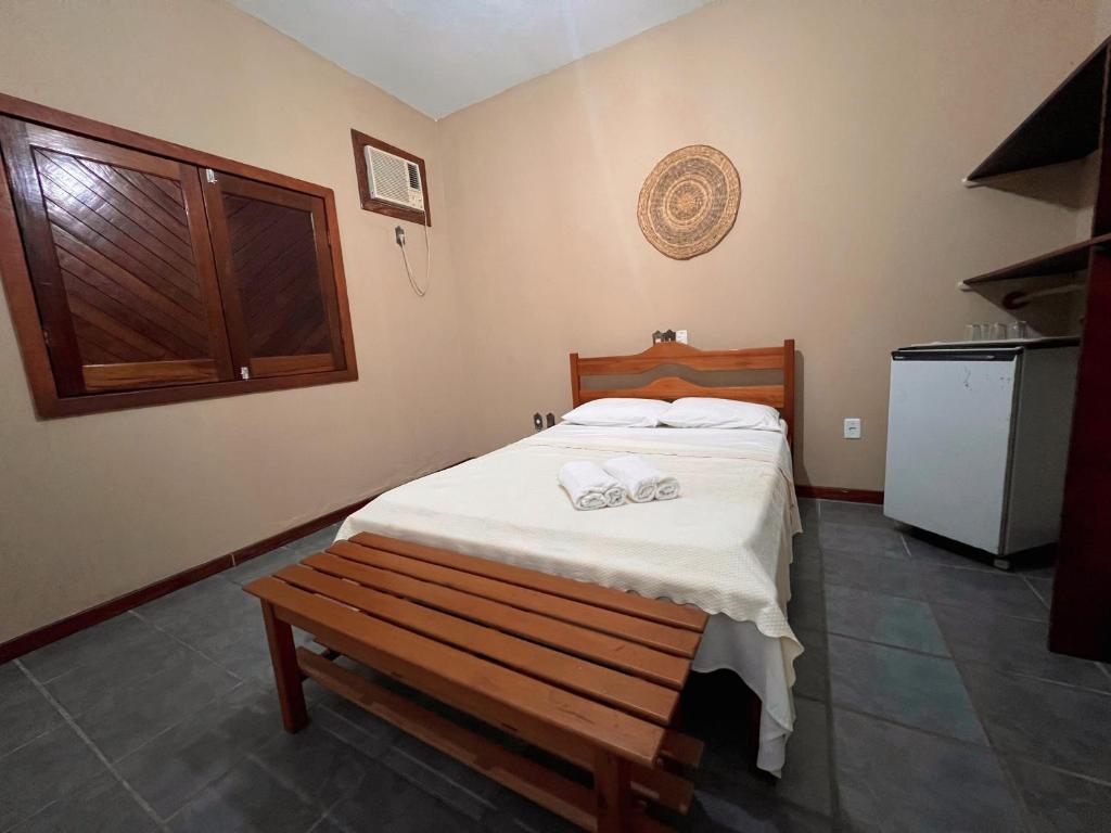 1 dormitorio con cama y banco. en Pousada Pitanga, en Prado