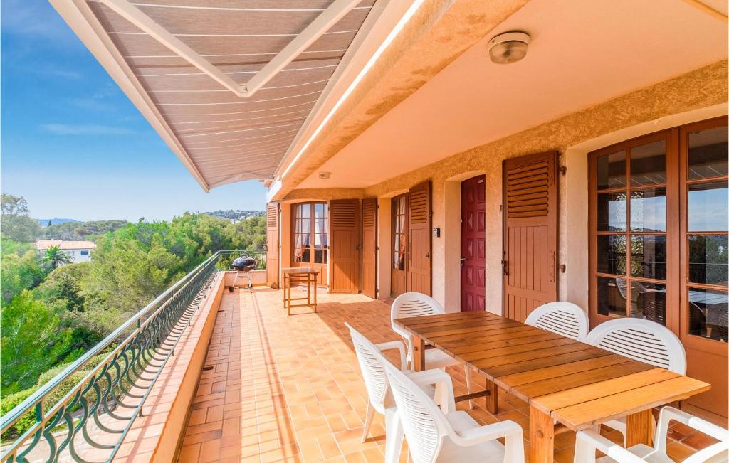 d'un balcon avec une table en bois et des chaises blanches. dans l'établissement Domaine De La Bastide Da, à Agay