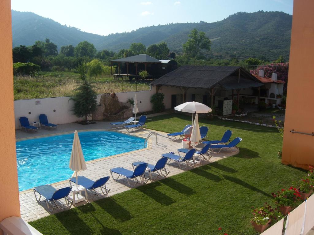 a view of a swimming pool with chairs and umbrellas at Vamvini Hotel in Sarti