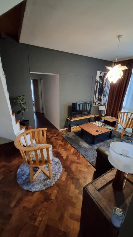 sala de estar con silla y sofá en Dpto panorámico chic microcentro en Mendoza