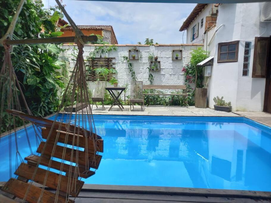 a pool with a hammock in front of a house at Casa grande,3 min a pé do Centro, grupos, familias in Paraty
