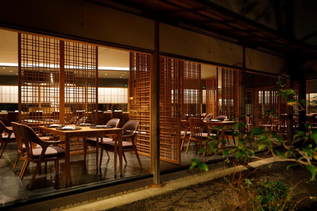 a dining room with tables and chairs and windows at Hotel Nikko Kanazawa in Kanazawa