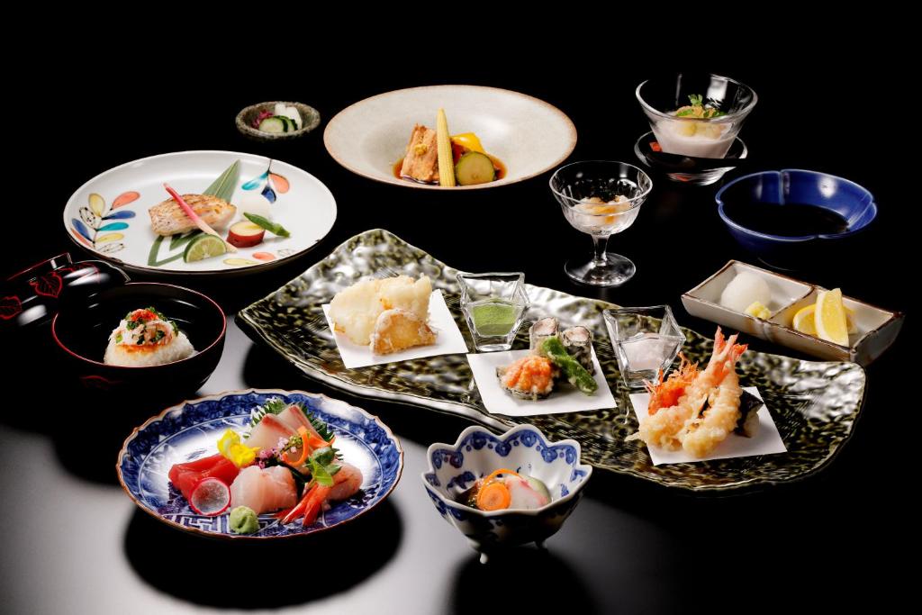 a table with plates of food on a table at Hotel Nikko Kanazawa in Kanazawa