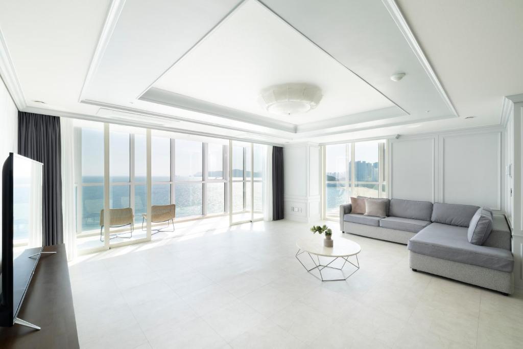 a living room with a couch and a table at Pale De Cz Condo in Busan