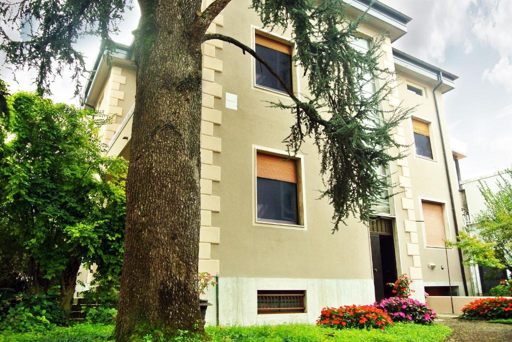 un edificio bianco con un albero di fronte di Villa Laila Bed & Breakfast a Lodi