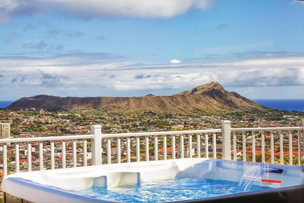 a bath tub sitting on top of a balcony with a mountain at Hibiscus in Honolulu
