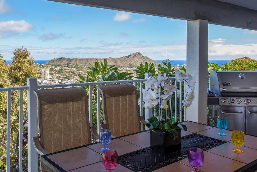 a balcony with a table with a view of the ocean at Lillikoi in Honolulu