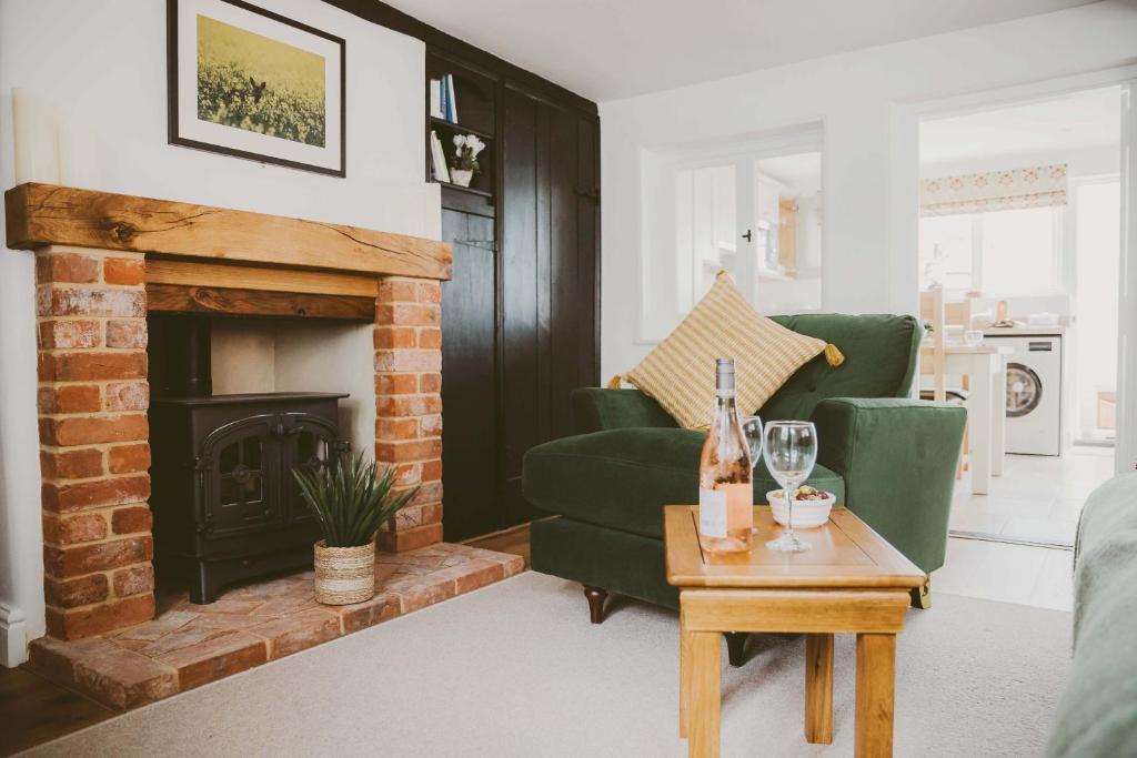 a living room with a fireplace and a green couch at 1 Chantry Cottage in Tunstall