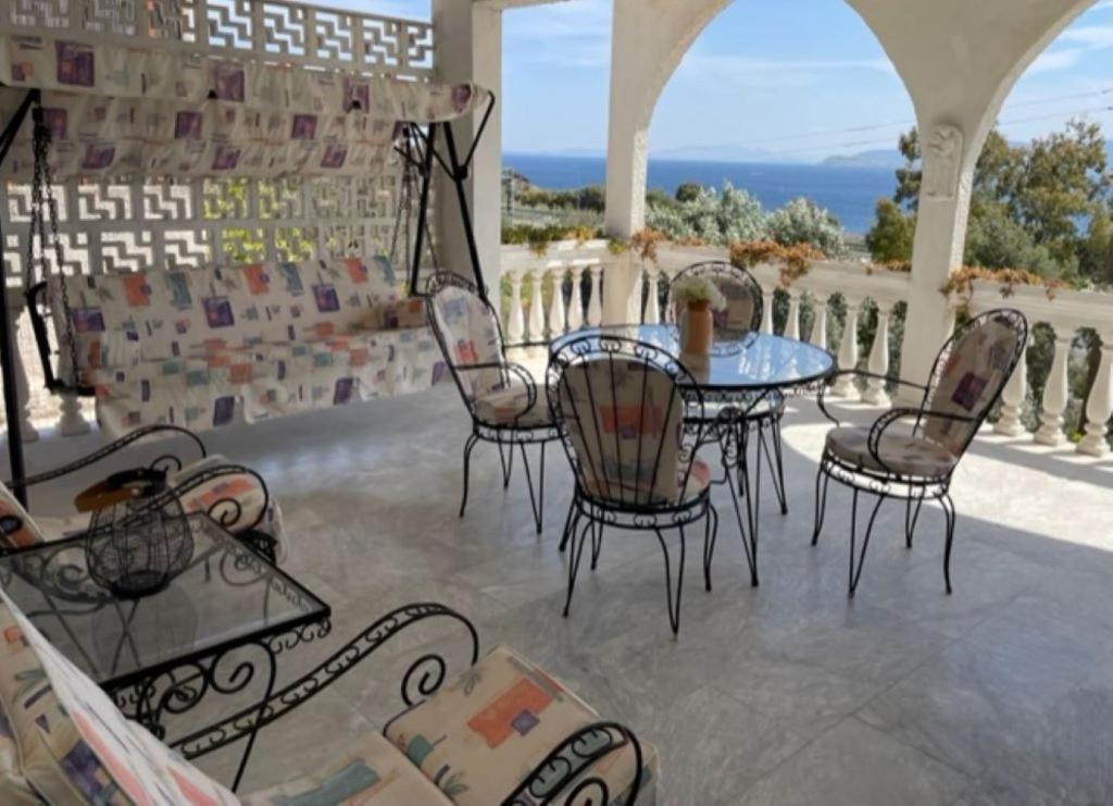 a patio with a table and chairs on a balcony at Country house by the Sea 200m & Sea View with garden in Agioi Theodoroi