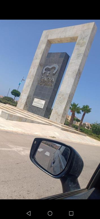 uno specchio retrovisore di un'auto di fronte a un monumento di Marina saidia a Oujda