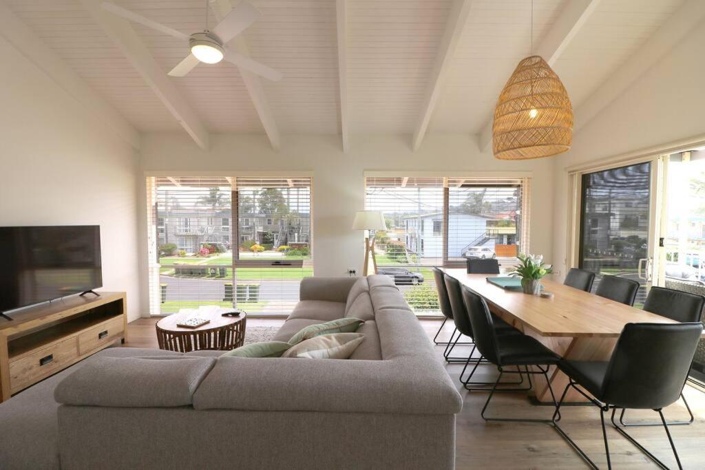 a living room with a couch and a dining table at Beach Haven in Merimbula