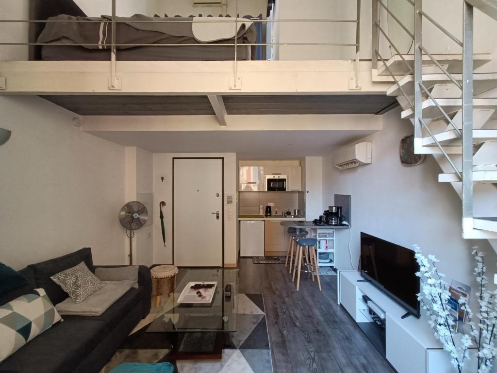 een woonkamer met een bank en een loft bij Duplex cathédrale in Cannes