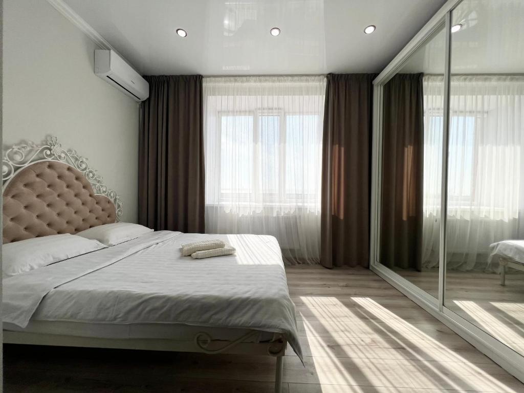 sypialnia z łóżkiem i dużym oknem w obiekcie Квартира в элитном ЖК w mieście Pawłodar