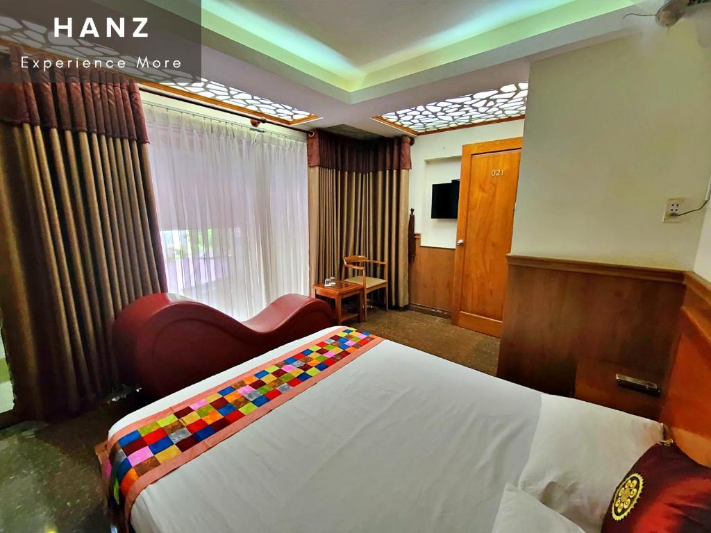 une chambre d'hôtel avec un lit et une chaise dans l'établissement HANZ Hien Lam Hotel, à Hô-Chi-Minh-Ville