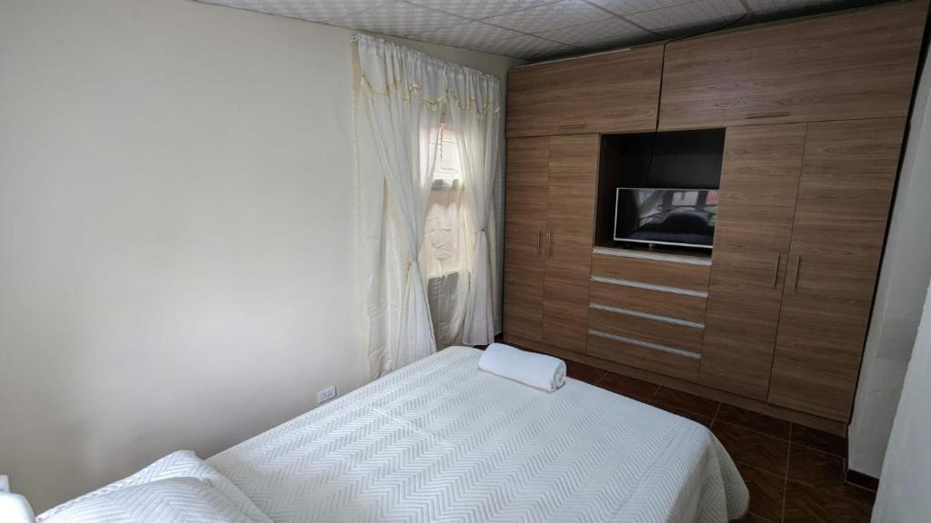 a small bedroom with two beds and a tv at La casita in Cochabamba