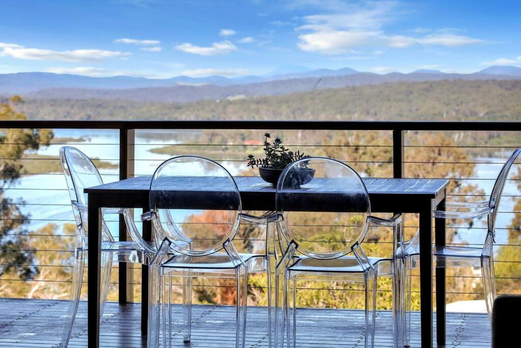 a table and chairs on a balcony with a view at Aqua La Vista - 4 Bedroom Pet Friendly House in Merimbula