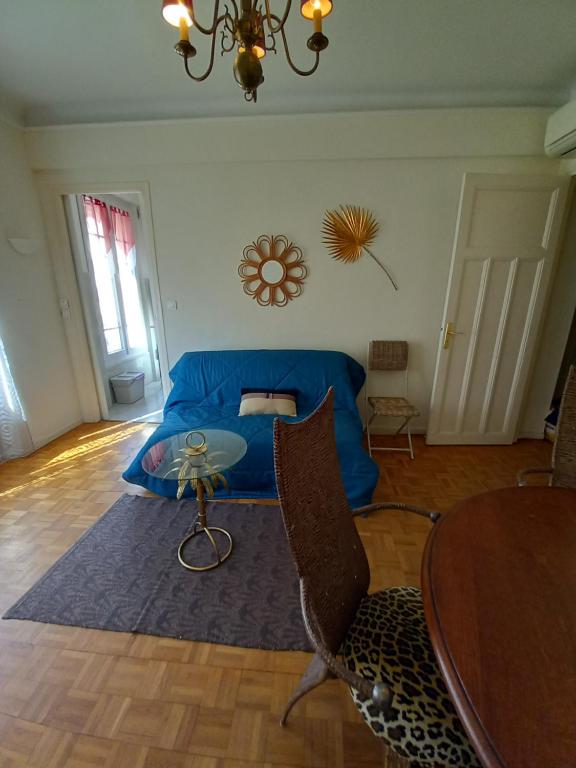 - une chambre avec un lit bleu et une table dans l'établissement Appartement hyper-centre Croisette Cannes, à Cannes