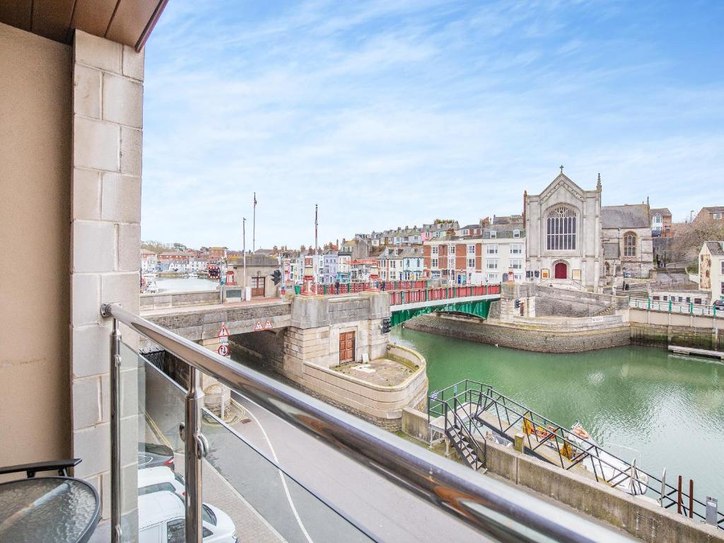 una vista da un balcone di un fiume con ponte di Harbourside Landing a Weymouth