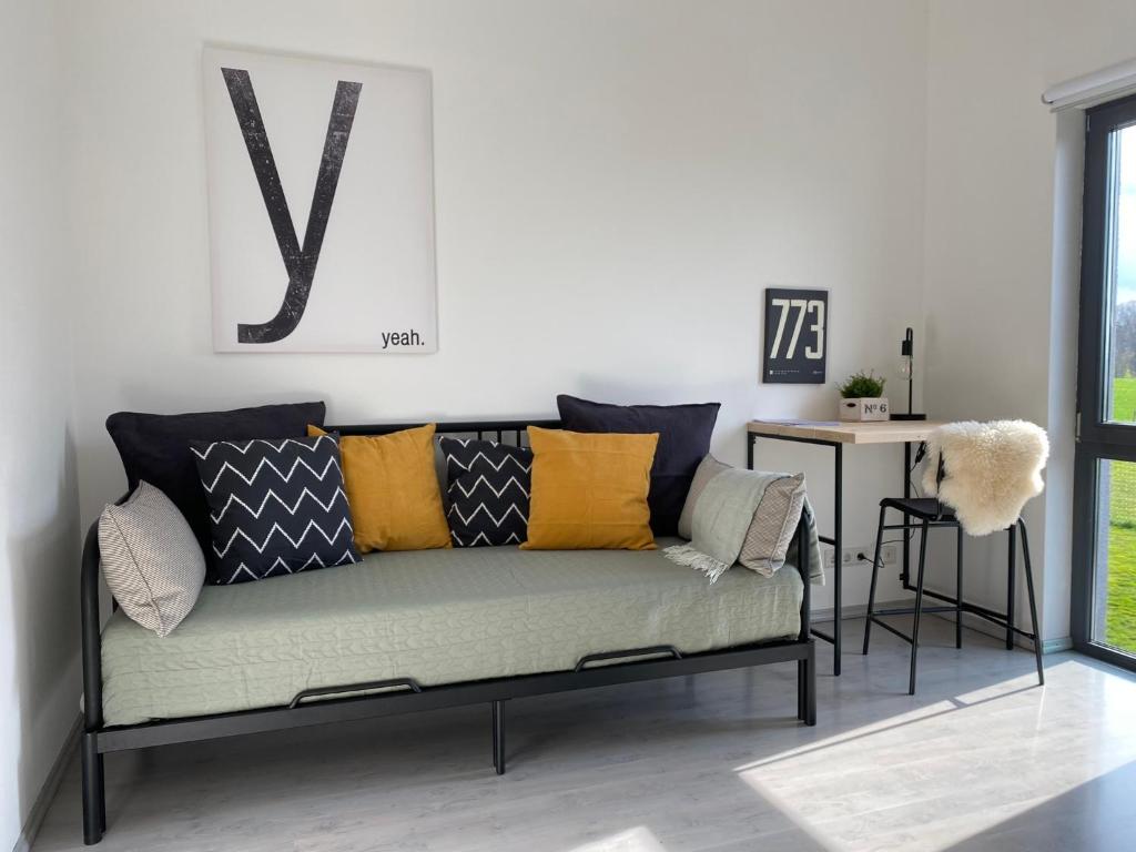 un sofá en una sala de estar con una V en la pared en Moderne 70 qm Ferienwohnung in Waldrandlage, en Eppelborn