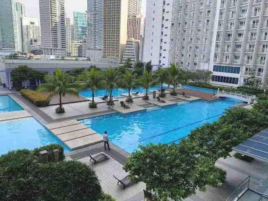 uma grande piscina com palmeiras numa cidade em 2 BR Condo Jazz cozy at best deal! em Manila