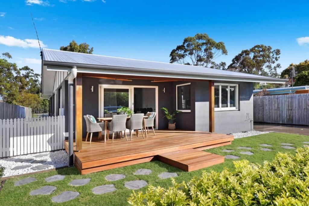 une maison avec une terrasse en bois dans la cour dans l'établissement Beach Boutique With River View, à Maroochydore