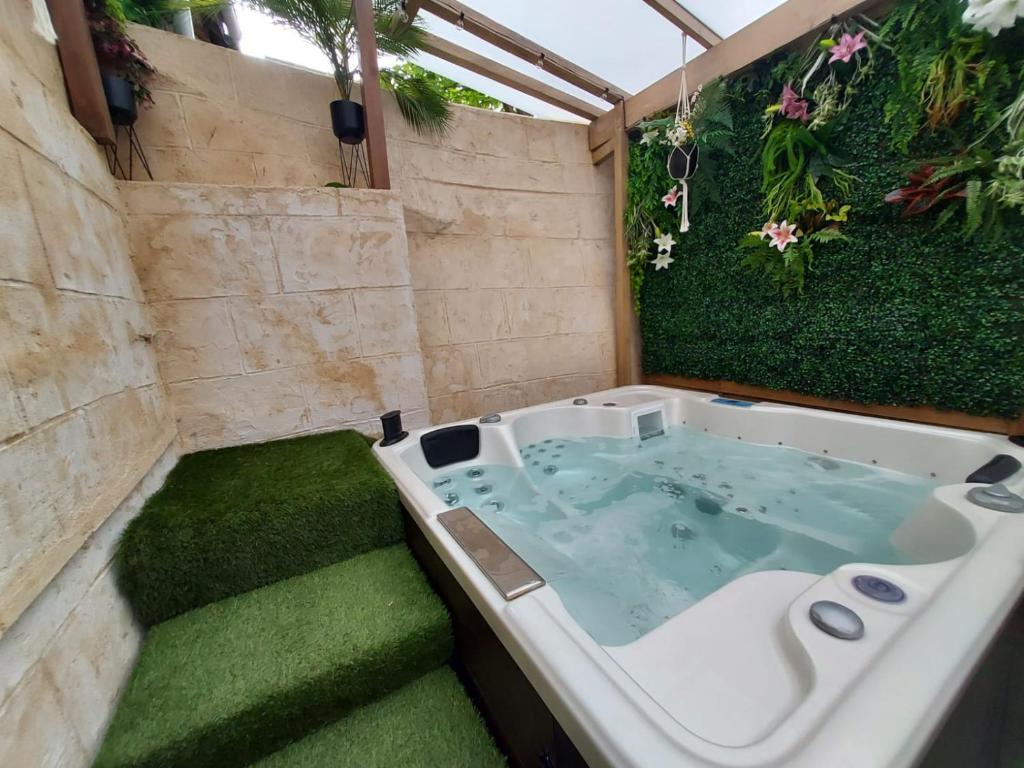 a jacuzzi tub in a garden with plants at suite spa jacuzzi tout confort in Beaumont-sur-Oise