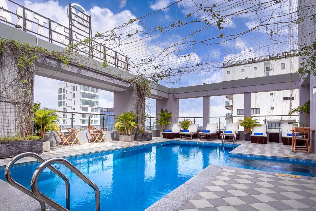 a swimming pool with chairs and tables on a building at HM Grand Central Hotel in Phnom Penh