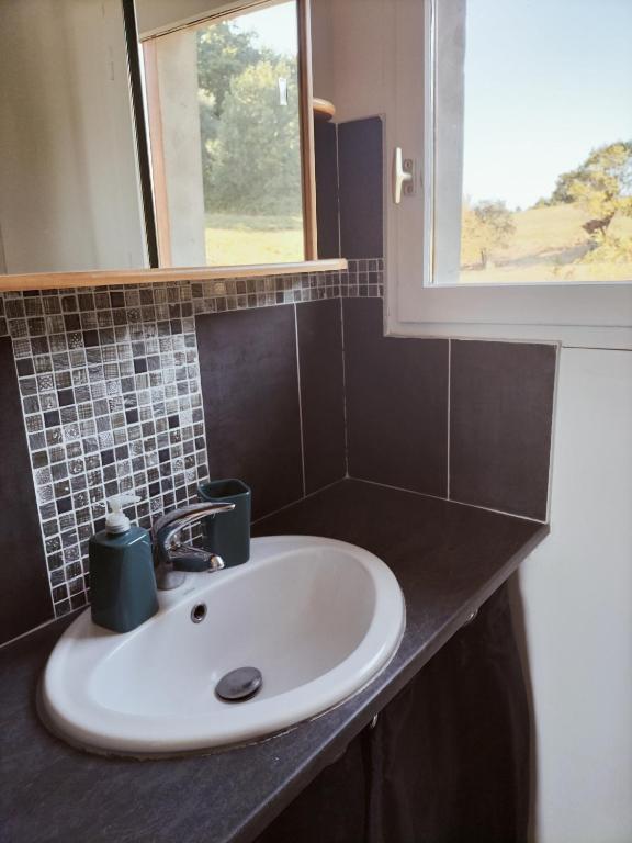 a sink in a bathroom with a window at A deux pas de Cabourg ,avec une belle vue sur la campagne normande.A grangues in Grangues