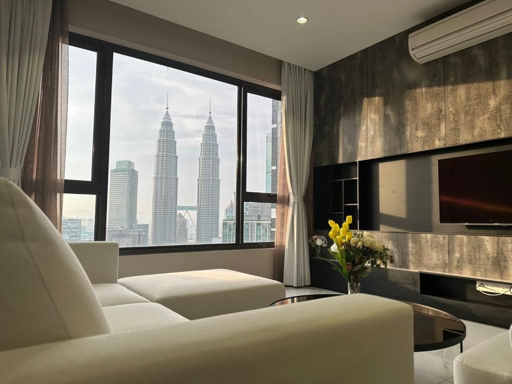 a living room with a white couch and a large window at ASTRA @ 8 Kia Peng Suites in Kuala Lumpur