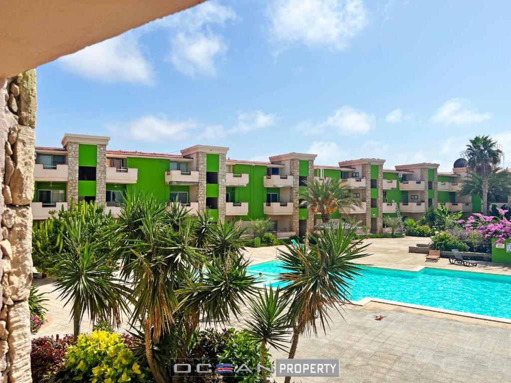 uma vista para um resort com uma piscina e palmeiras em Djadsal Moradias em Santa Maria