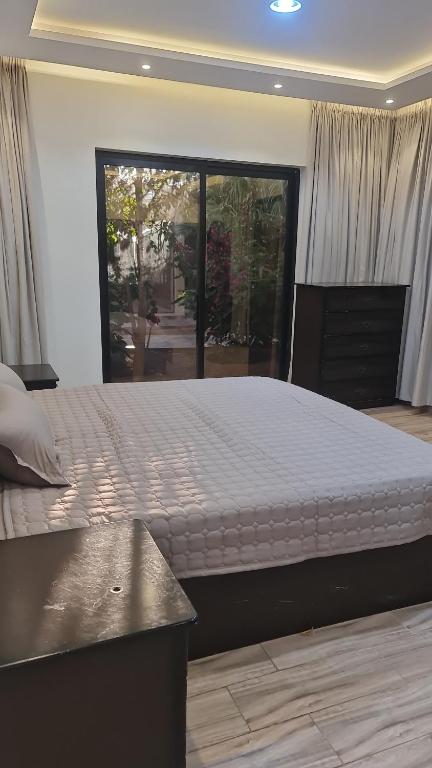 duże łóżko w sypialni z dużym oknem w obiekcie استراحة وشاليه الكوخ w mieście Unajza