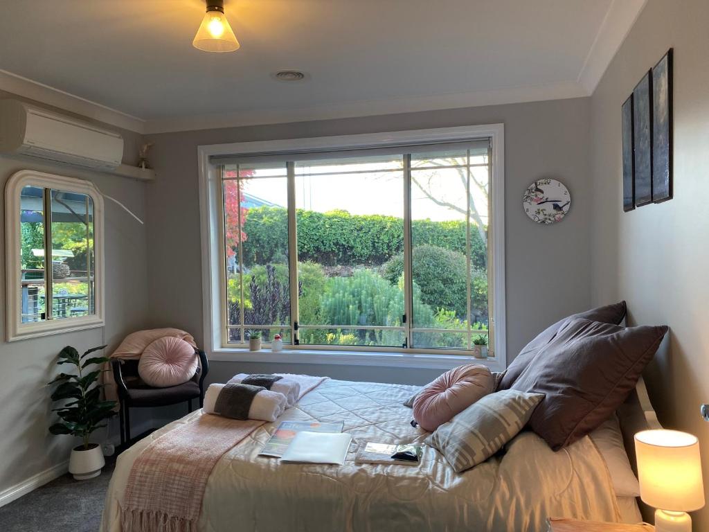 1 dormitorio con cama y ventana grande en Rocky Rest en Orange