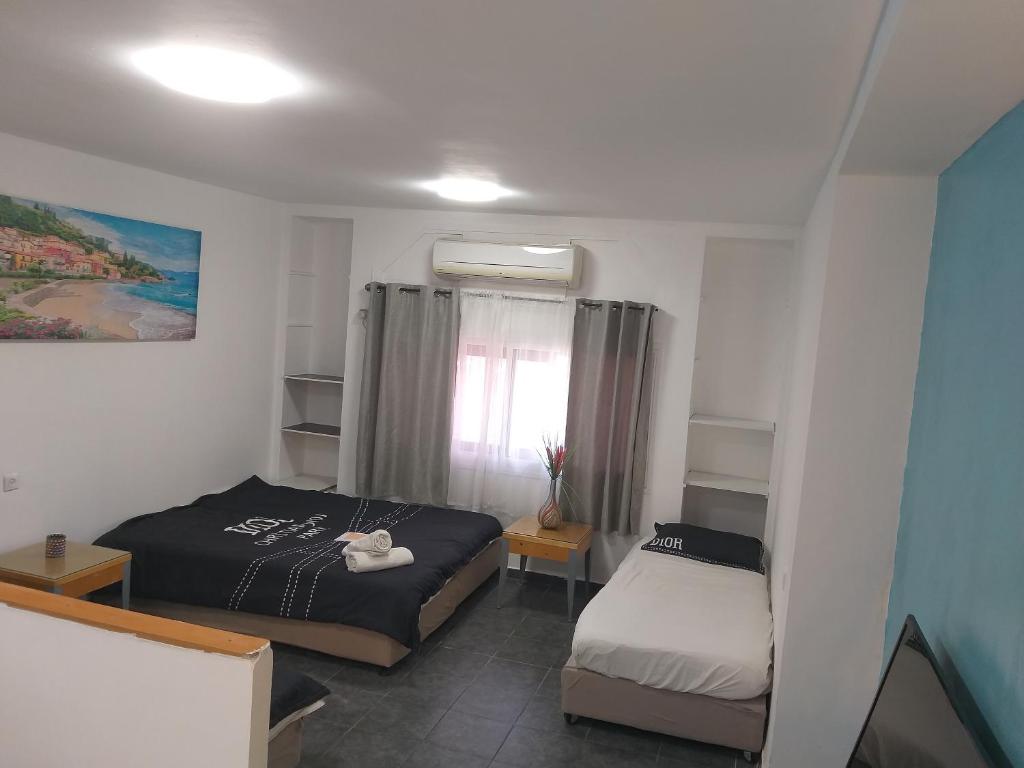 a small bedroom with two beds and a window at דירת נופש במרכז תיירות אילת in Eilat