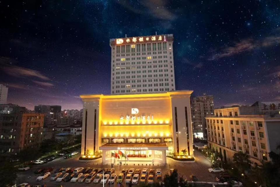 a large building with lights on it at night at Shenzhen Shuidu Holiday Hotel, North Railway Station in Shenzhen