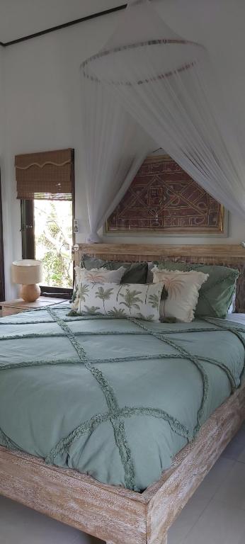 ein Schlafzimmer mit einem großen Bett mit Baldachin in der Unterkunft Villa Gede Private Guest House in Selemadeg