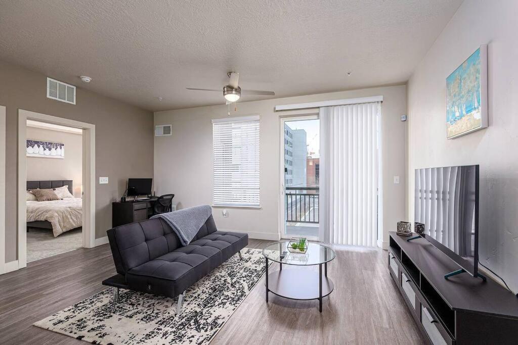 a living room with a couch and a television and a bed at Modern 1B Downtown SLC with WFH Setup, Gym, Fast Wi-Fi, Pool in Salt Lake City