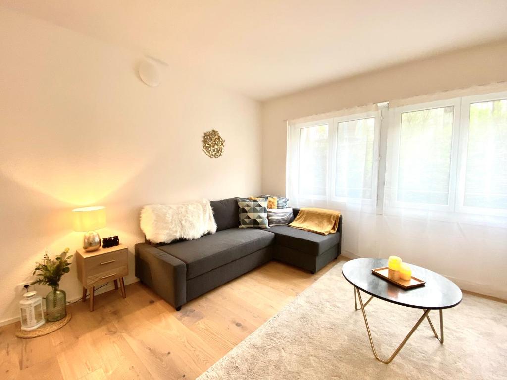 sala de estar con sofá y mesa en GLAD Spot - Liestal - 10 min from Basel - Central, Design & Netflix en Liestal