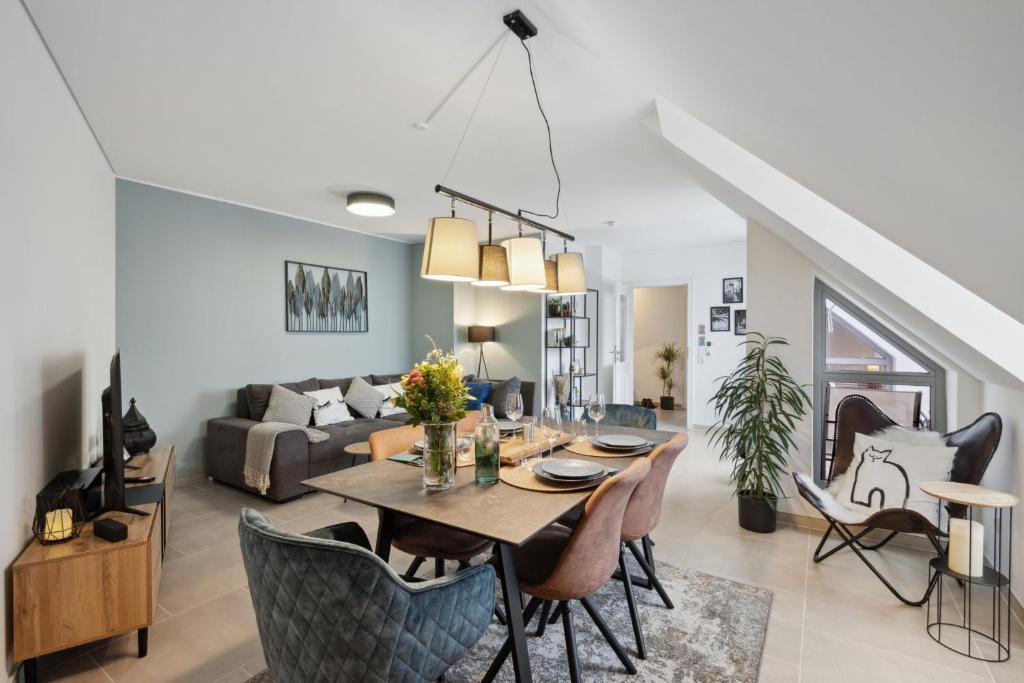 a dining room and living room with a table and chairs at smooth living Apartments Augsburg Lechhausen - Free parking in Augsburg