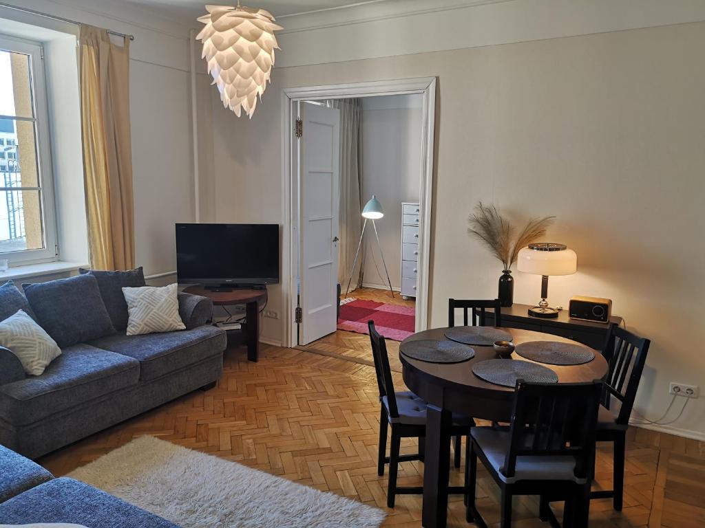 een woonkamer met een bank en een tafel met stoelen bij Gonsiori 3 Tenors Apartment in Tallinn