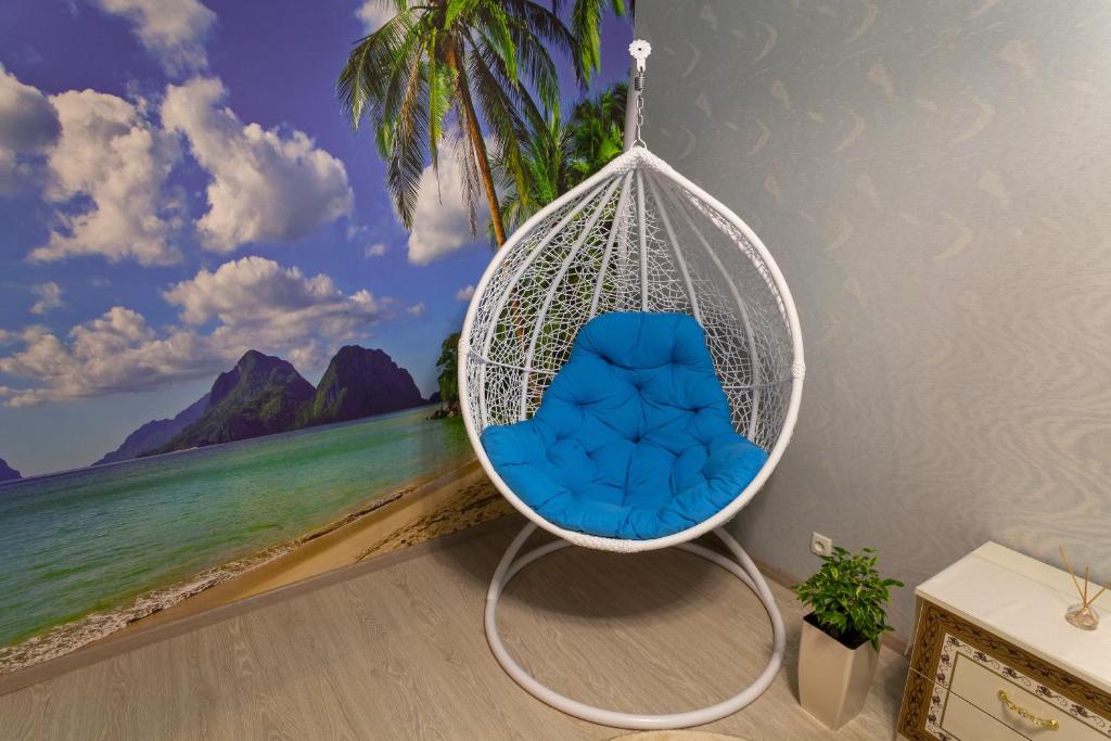 a swing with a blue chair in front of a beach at Luxury apartment Sicheslavska street in Kryvyi Rih