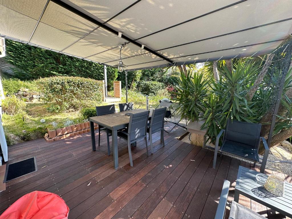 a patio with a table and chairs and an umbrella at Le Bastidon in Sanary-sur-Mer