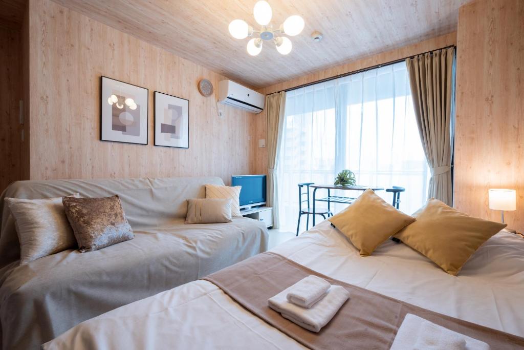 a bedroom with two beds and a large window at A-Style Matsu 602 in Osaka