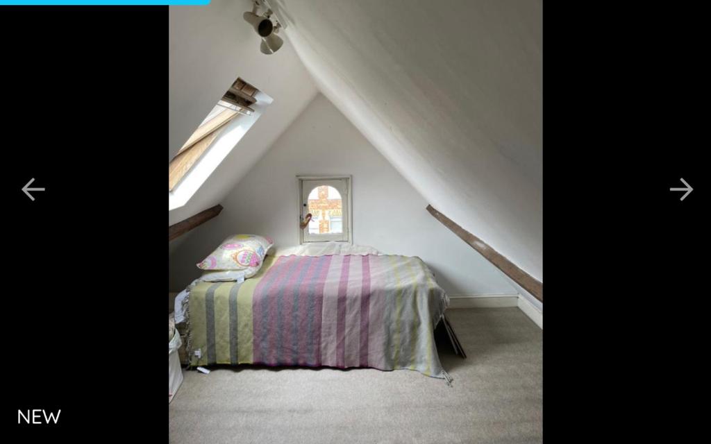 a bedroom with a bed in a attic at Cedar House in London