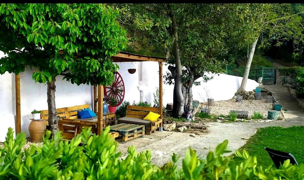 une terrasse couverte avec un banc et des arbres dans une cour dans l'établissement Larrion Hostal - Ostatua, à Larrión