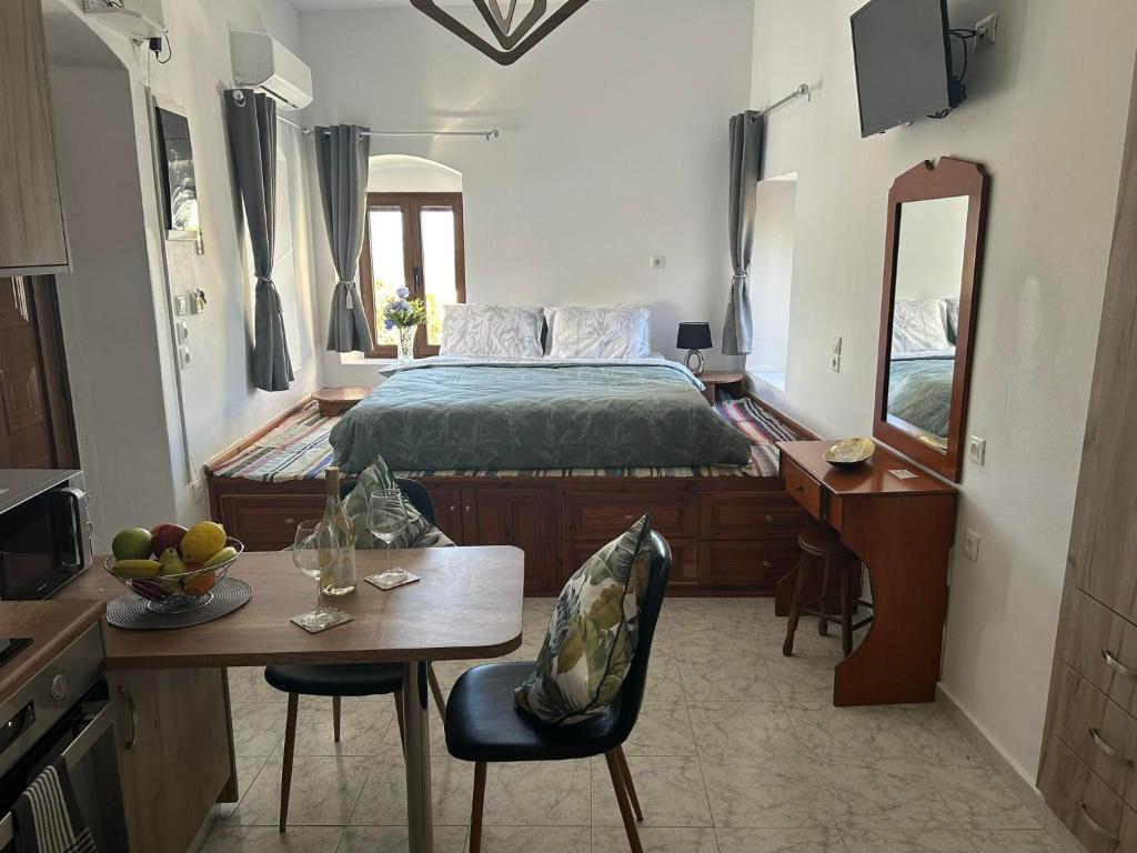 a bedroom with a bed and a table and chairs at New Lindos Studio 45 renovated in Líndos