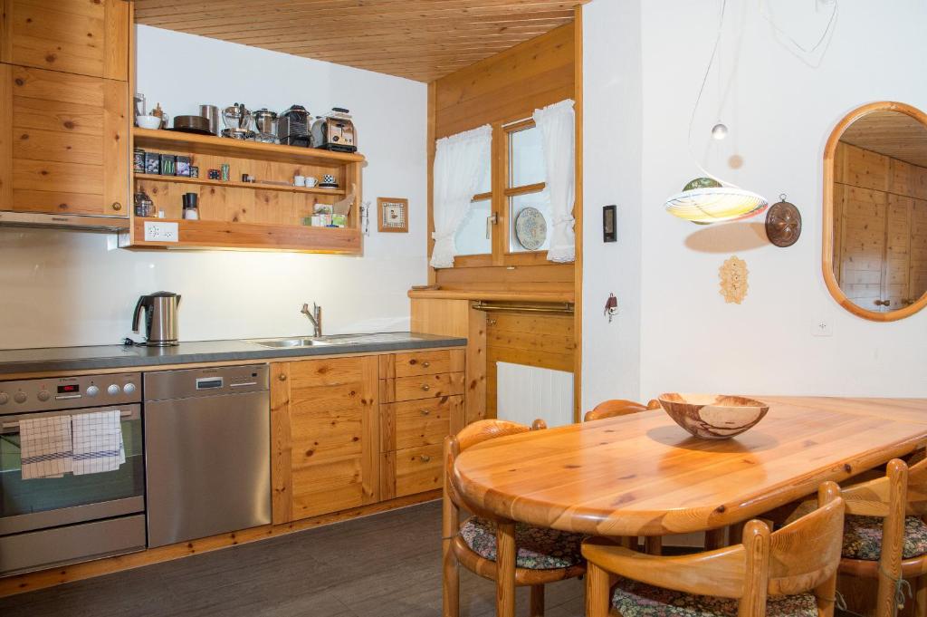 eine Küche mit einem Holztisch und Holzschränken in der Unterkunft Ferienwohnung Schweizerhof 604 Lenzerheide in Lenzerheide