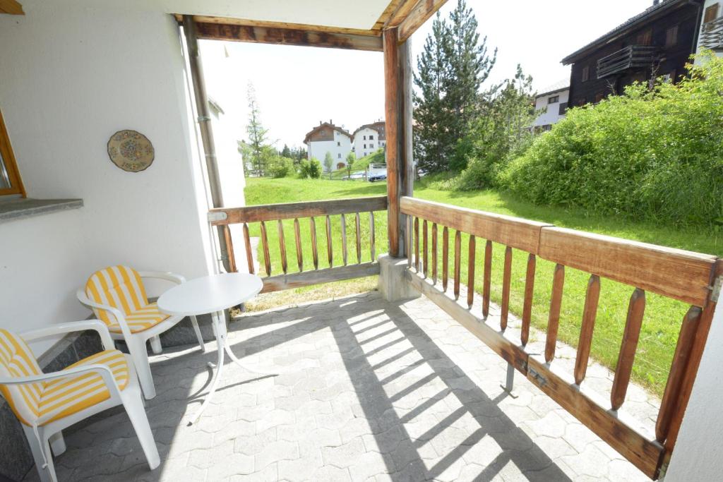 a balcony with a table and chairs and a view at Apartment with hotel spa and pool in Lenzerheide